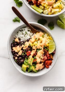 A vegan burrito bowl with rice and veggies topped with chipotle crema