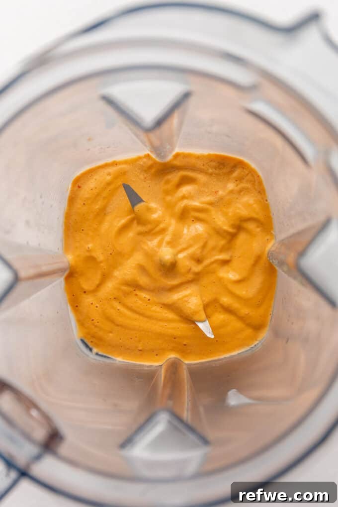 Smooth, creamy chipotle cashew sauce swirling inside a blender container, perfectly blended.