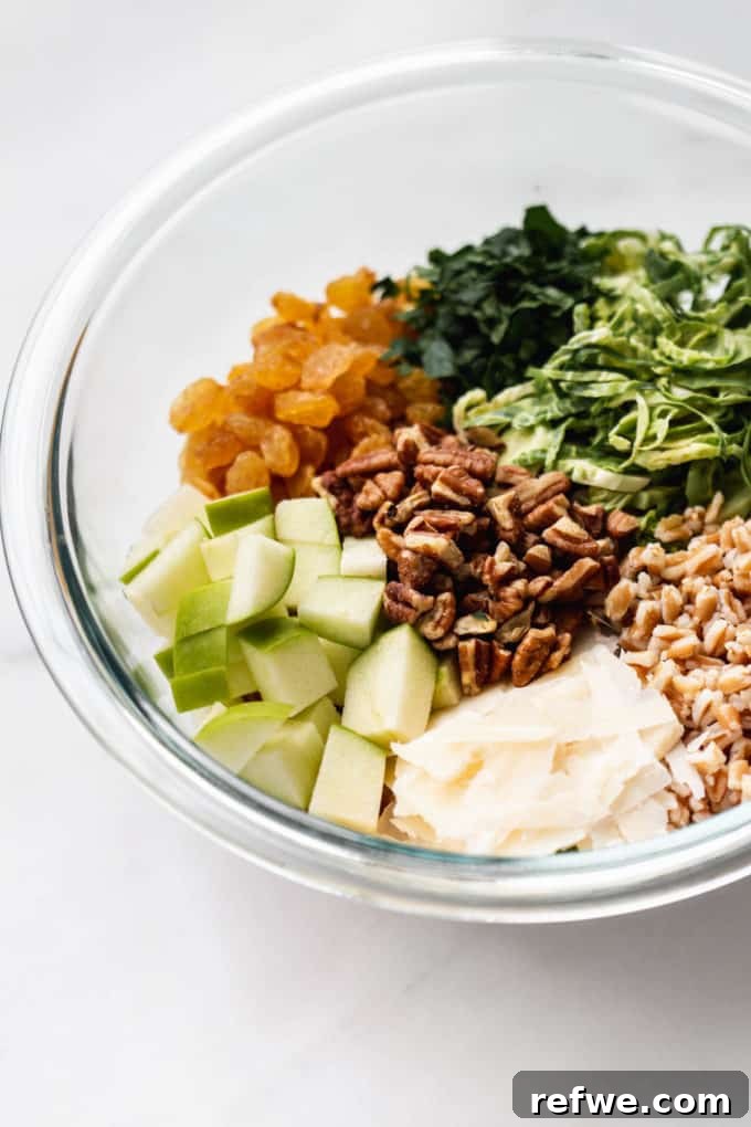 A beautifully presented bowl of farro salad, filled with colorful ingredients like grains, apples, and various greens.