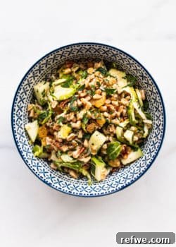 A blue and white bowl with farro salad in it, showing a close-up of the delicious textures.