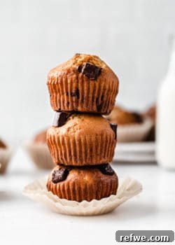 Stacked banana muffins with chocolate chunks, highlighting their appealing texture.
