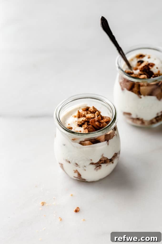 Cinnamon Apple Parfait Stacks 5 A single jar of layered Greek yogurt, cooked apples, and granola, showcasing the distinct layers.
