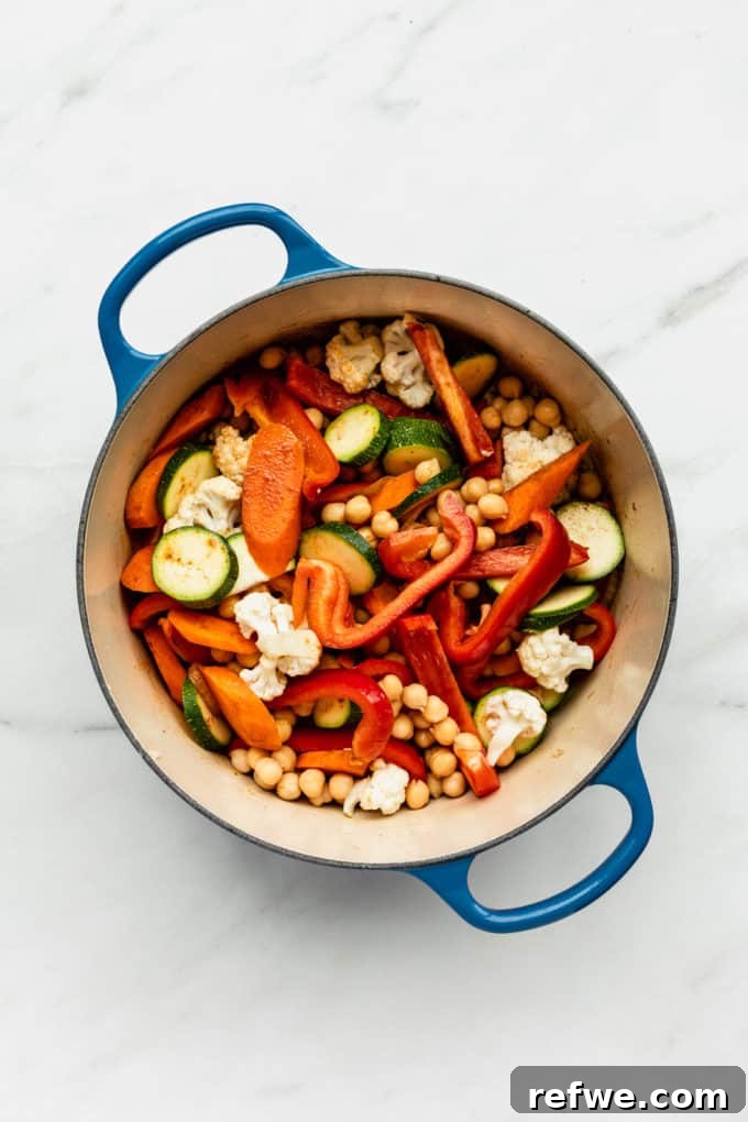 Moroccan Spice Garden Tagine 4 A colorful medley of mixed vegetables tossed with spices in a blue cooking pot, ready for simmering into a tagine.