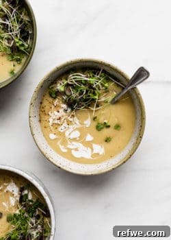 a bowl of roasted garlic soup topped with radish sprouts