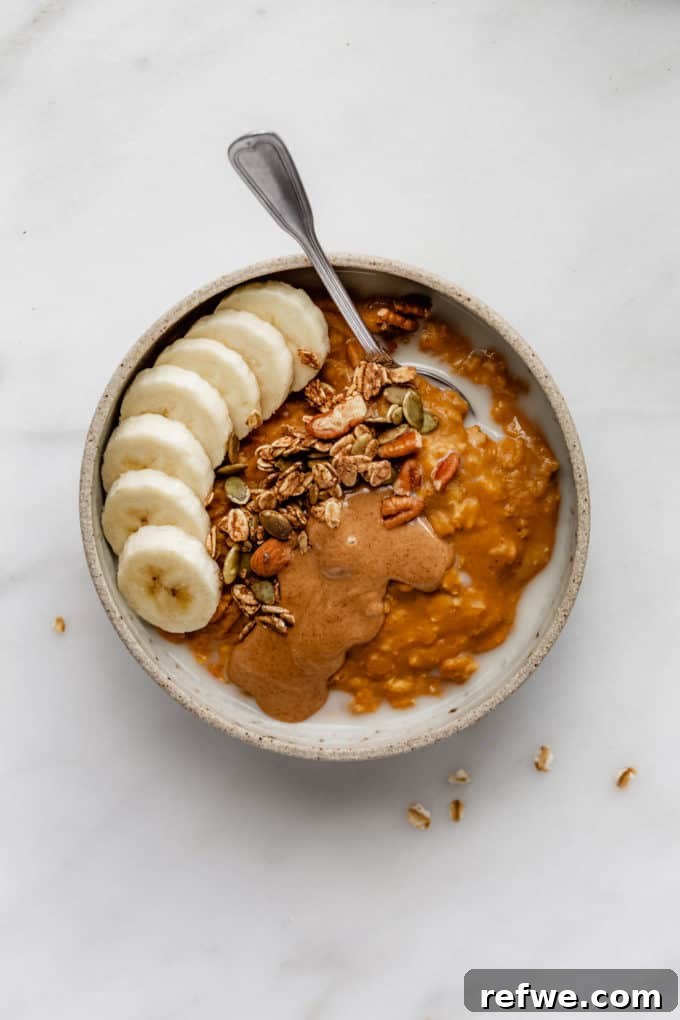 Autumn Pumpkin Spice Oats 3 pumpkin pie oatmeal in a bowl topped with bananas, granola and almond butter, a perfect morning meal