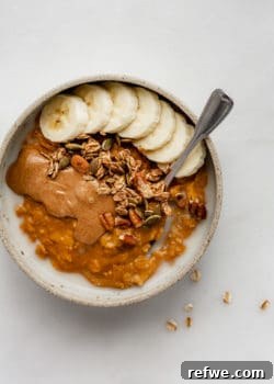 pumpkin oatmeal in a bowl topped with bananas and granola