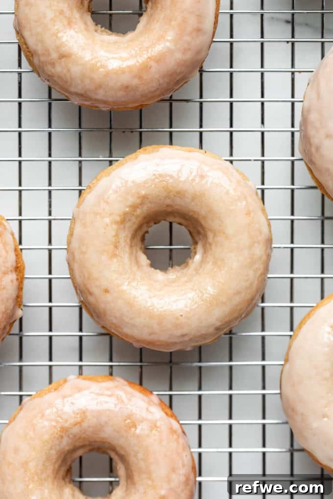 Sweet & Salty Vegan Maple Rings 3 Freshly baked maple donuts cooling on a metal rack