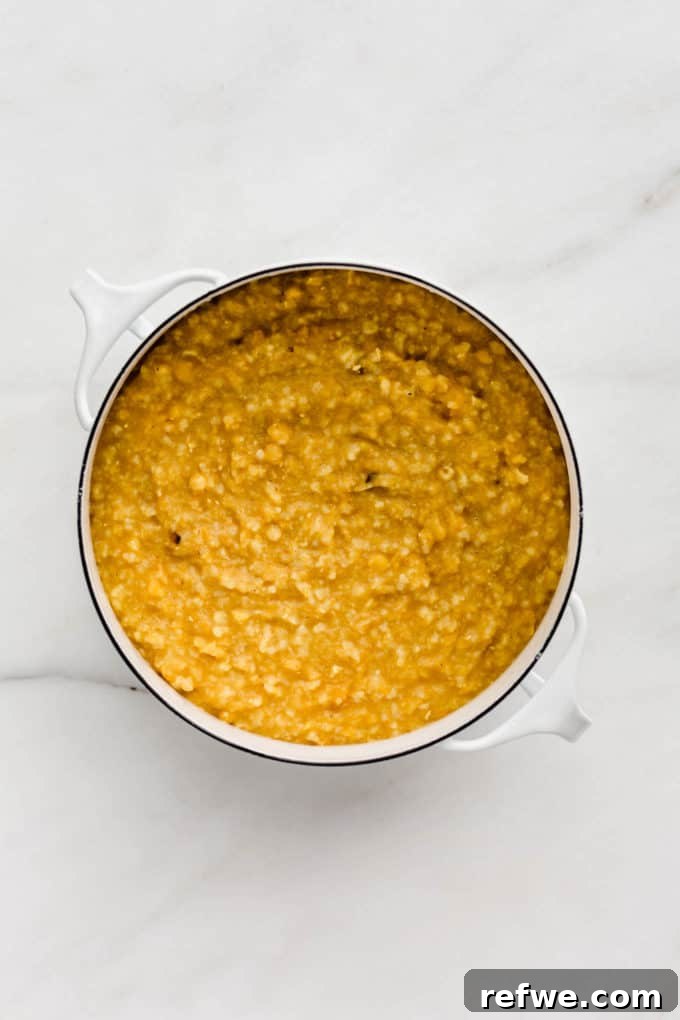 Creamy, stew-like Kitchari simmering in a white pot, ready to be served.