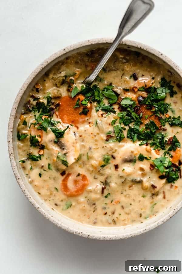 Heartwarming Plant-Based Soups for Cozy Days 15 A hearty and creamy wild rice soup in a bowl, garnished with fresh parsley.