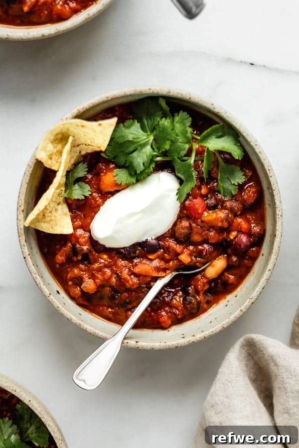 Heartwarming Plant-Based Soups for Cozy Days 16 A steaming bowl of vegan chili, richly colored and topped with fresh cilantro.