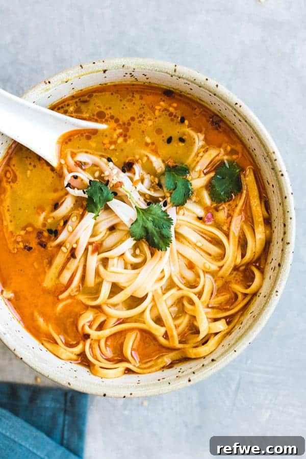 Heartwarming Plant-Based Soups for Cozy Days 18 A vibrant bowl of Northern-Style Vegan Thai Coconut Soup with noodles and herbs.