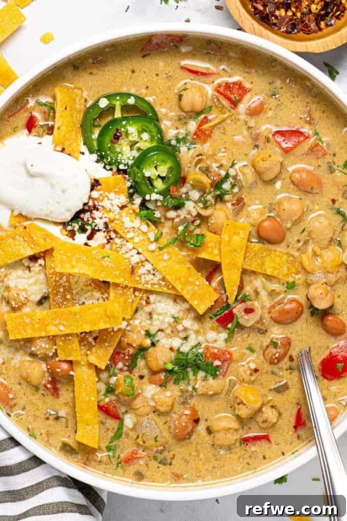 Heartwarming Plant-Based Soups for Cozy Days 21 A bowl of creamy vegan white chickpea chili, garnished with avocado and cilantro.