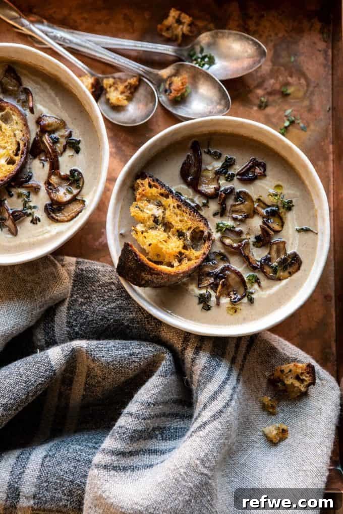 Heartwarming Plant-Based Soups for Cozy Days 8 Rich cream of mushroom soup topped with golden garlic herb breadcrumbs.
