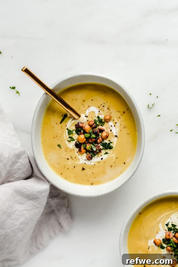 Heartwarming Plant-Based Soups for Cozy Days 9 A bowl of creamy yellow curried coconut cauliflower soup with roasted chickpeas.