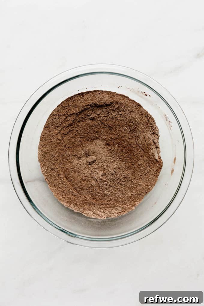 Wholesome Chocolate Pumpkin Delight 3 A clear glass mixing bowl containing a well-combined mixture of dry ingredients including flour and rich cocoa powder, ready for the wet ingredients.