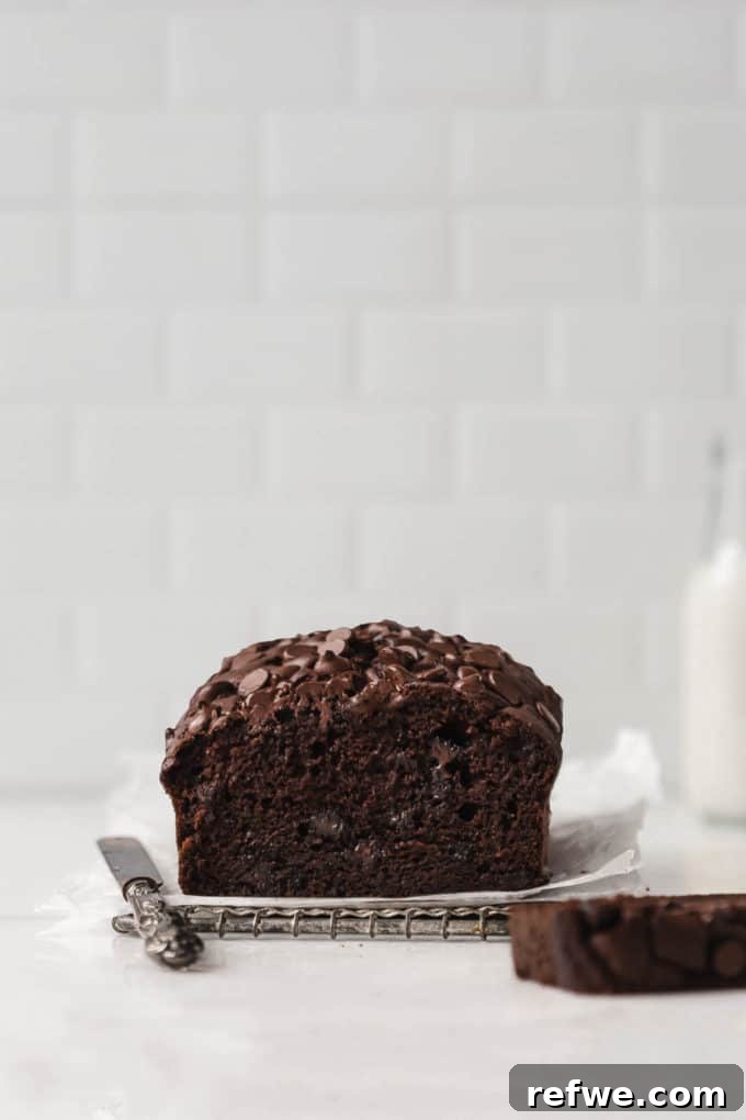 Wholesome Chocolate Pumpkin Delight 8 A beautiful loaf of healthy chocolate pumpkin bread displayed on a white marble table, with a perfect slice cut out, revealing its moist, chocolate-studded interior.
