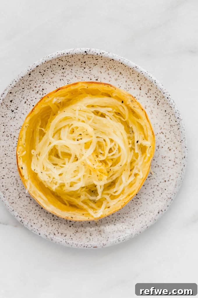 The Only Way to Cook Spaghetti Squash Perfectly 3 a ring of spaghetti squash on a white speckled plate
