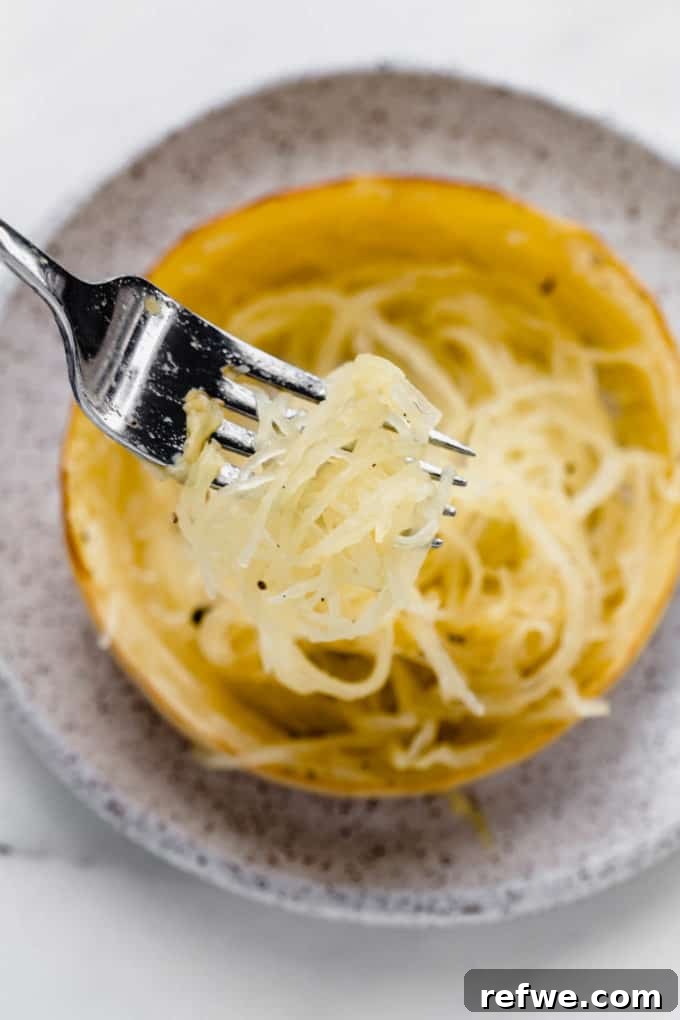 The Only Way to Cook Spaghetti Squash Perfectly 4 a fork scooping some spaghetti squash