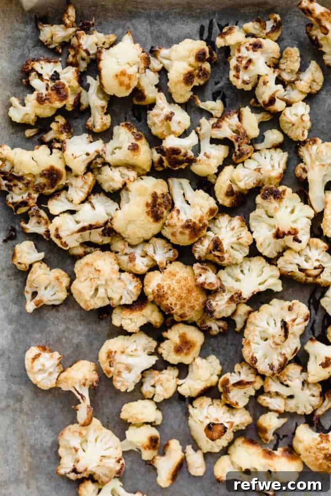 Spicy Peanut Kung Pao Cauliflower 4 Evenly spread cauliflower florets on a baking sheet, ready for roasting.