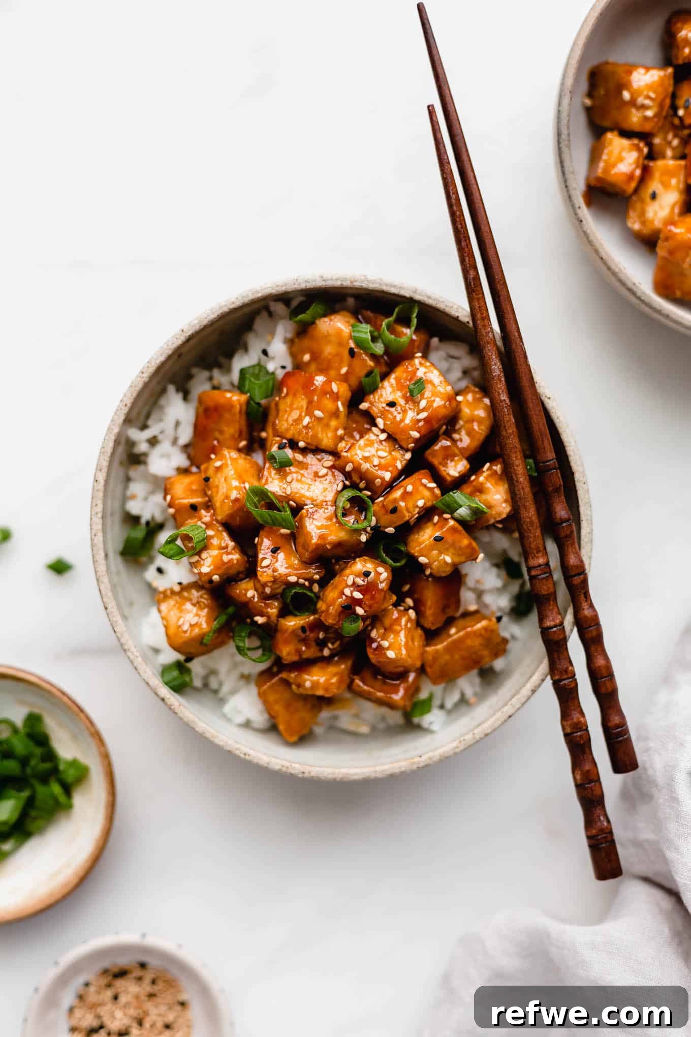 Caramelized Tofu 8 A bowl of sweet and sour tofu on a marble counter with wooden chopsticks