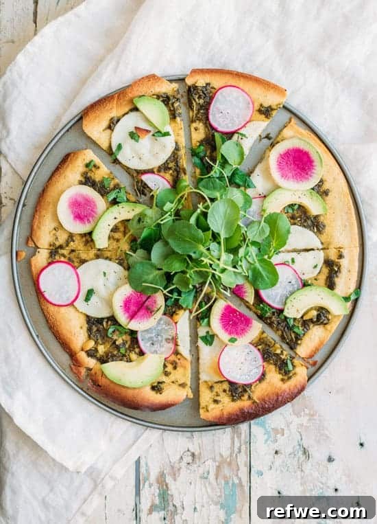 close-up of chickpea crust pizza with walnut pesto and fresh toppings
