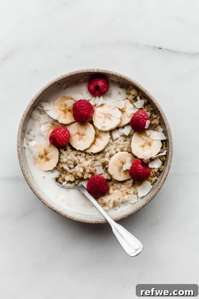 Morning Quinoa Nourishment 5 A wholesome Quinoa Breakfast Bowl featuring cooked quinoa, creamy coconut milk, vibrant banana slices, and a medley of fresh berries, creating a visually appealing and nutritious meal.