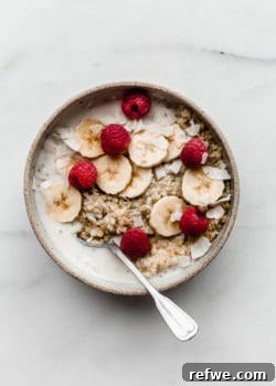 Quinoa in a ceramic bowl with coconut milk bananas and berries in it