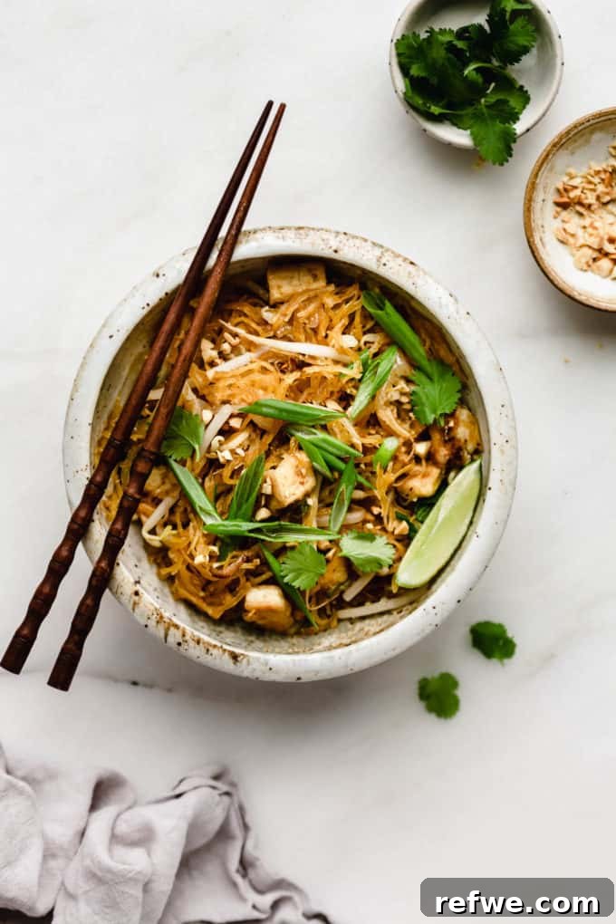 Squash Noodle Pad Thai 2 Spaghetti squash pad Thai in a white ceramic bowl, garnished with fresh cilantro and crushed peanuts