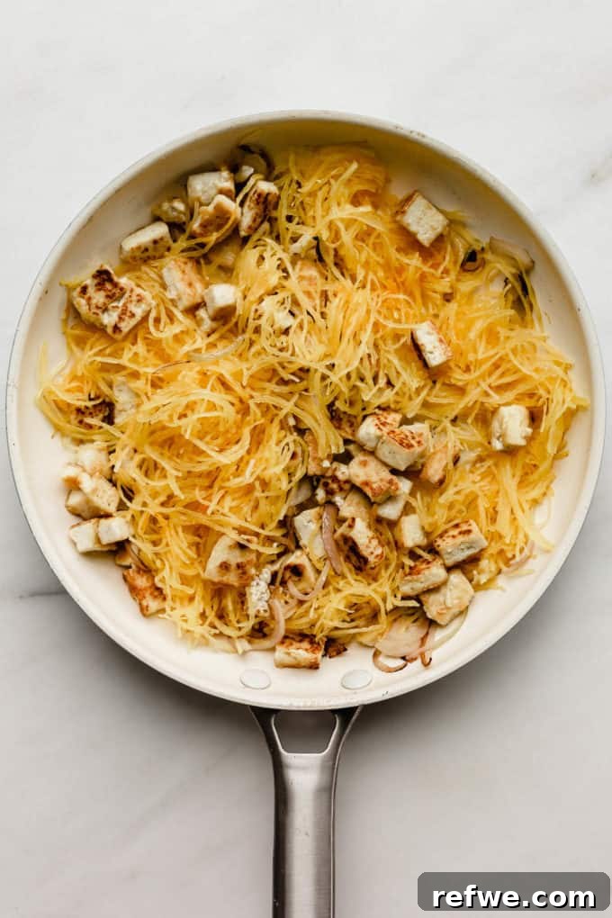 Squash Noodle Pad Thai 4 A white pan showing spaghetti squash strands mixed with golden-brown tofu cubes