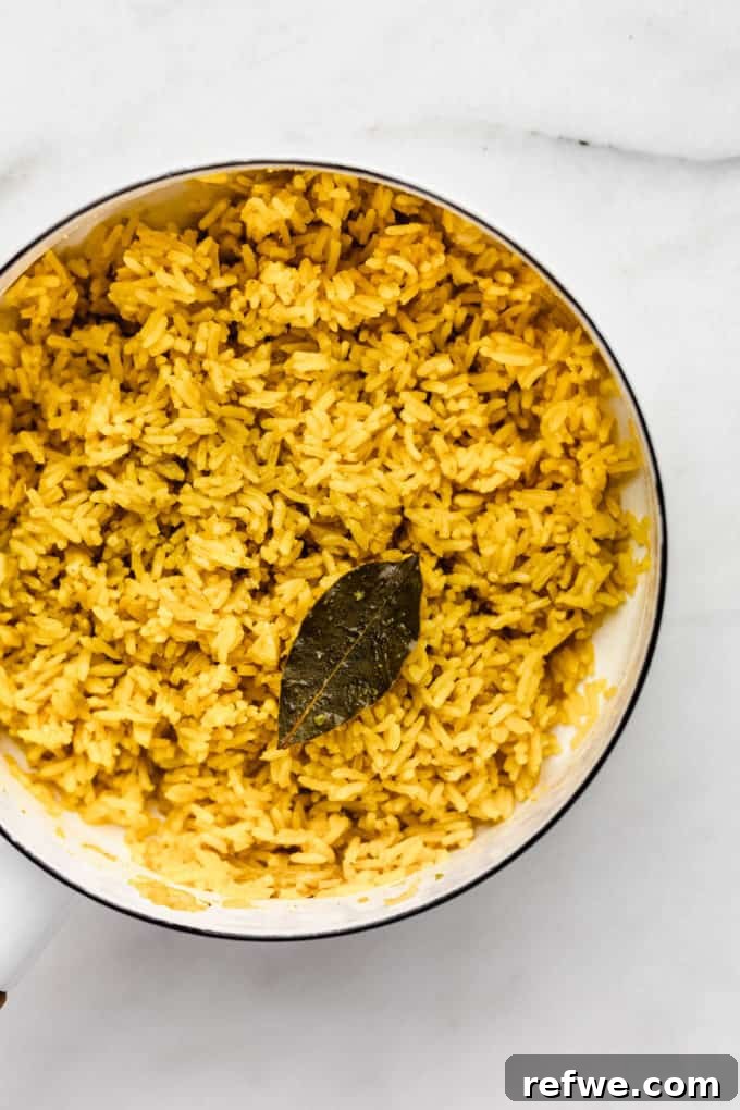 Golden Turmeric Rice 7 A close-up of vibrant turmeric rice in a white pot, fluffy and golden