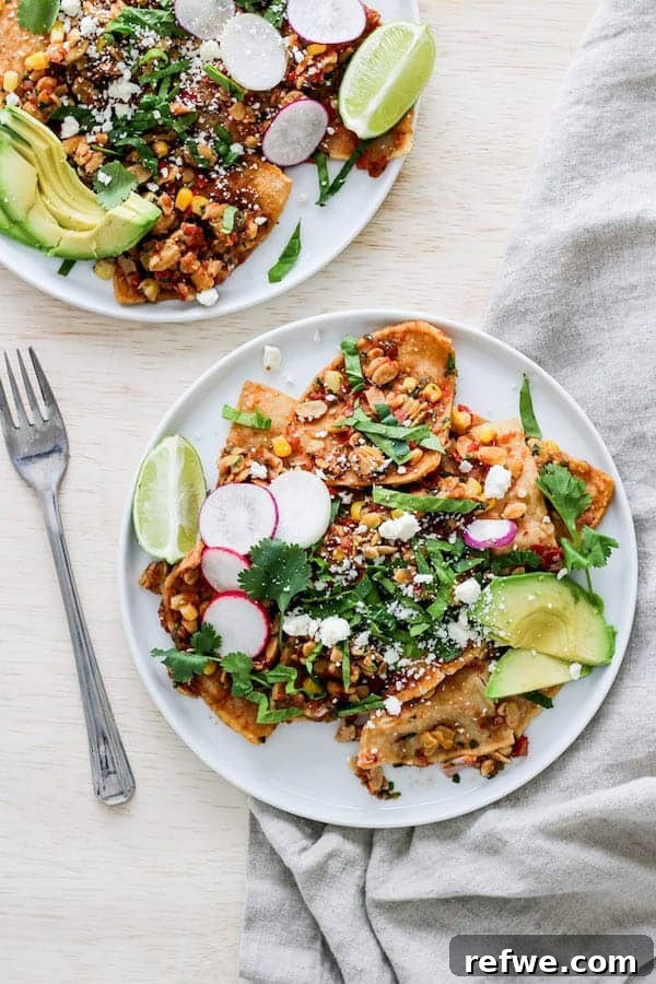 Unlock Tempeh's Potential 23 Recipes and a Full Cooking Guide 12 A plate of savory Tempeh Chilaquiles, generously topped with Mexican crumbled tempeh, fresh avocado, cilantro, and a lime wedge.