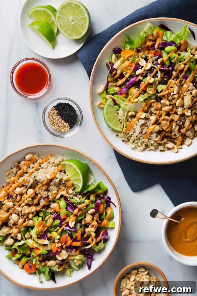 Unlock Tempeh's Potential 23 Recipes and a Full Cooking Guide 13 Two vibrant Buddha bowls overflowing with quinoa, colorful salad greens, orange-marinated tempeh, and a rich peanut sauce.