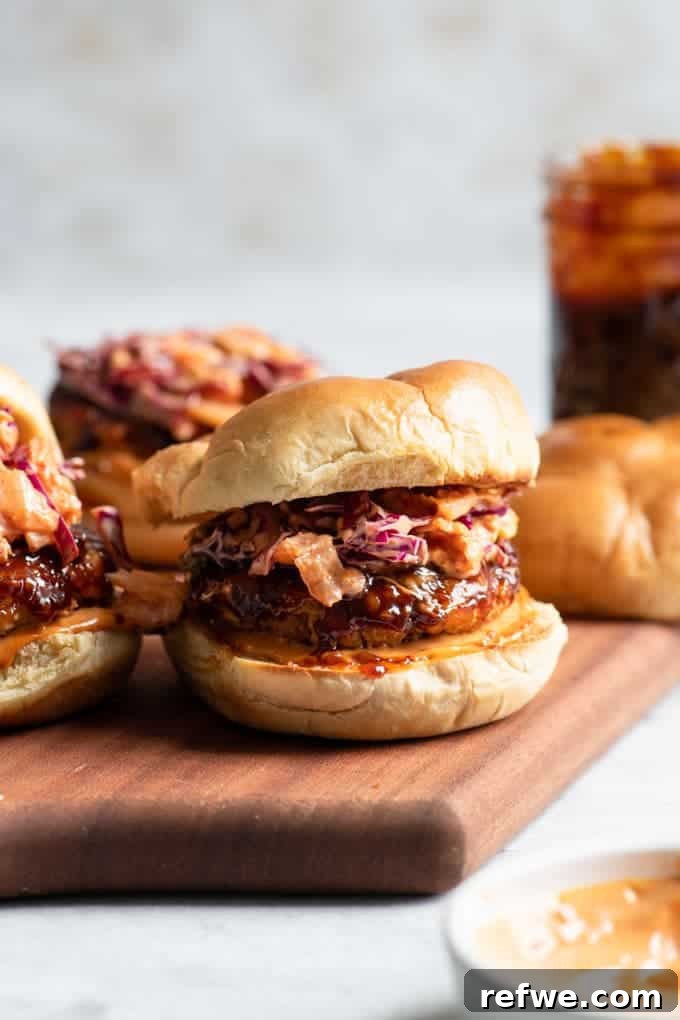 Unlock Tempeh's Potential 23 Recipes and a Full Cooking Guide 18 A wooden tray presenting mouth-watering Vegan Korean BBQ Burgers, layered with gochujang-marinated tempeh patties, Korean BBQ sauce, and kimchi slaw.