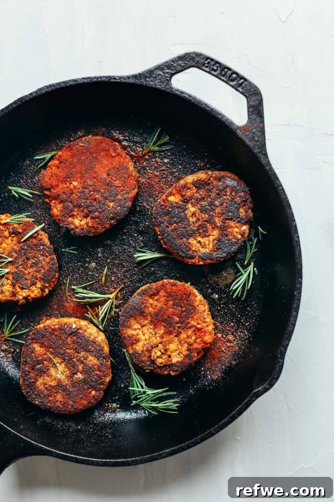 Unlock Tempeh's Potential 23 Recipes and a Full Cooking Guide 6 A cast iron skillet filled with savory and spicy tempeh breakfast sausage patties, ready to serve.