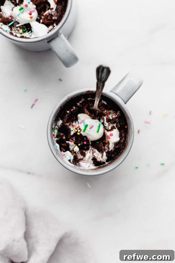 A delightful chocolate mug cake in a grey mug, with a spoon, highlighting its soft and inviting texture.