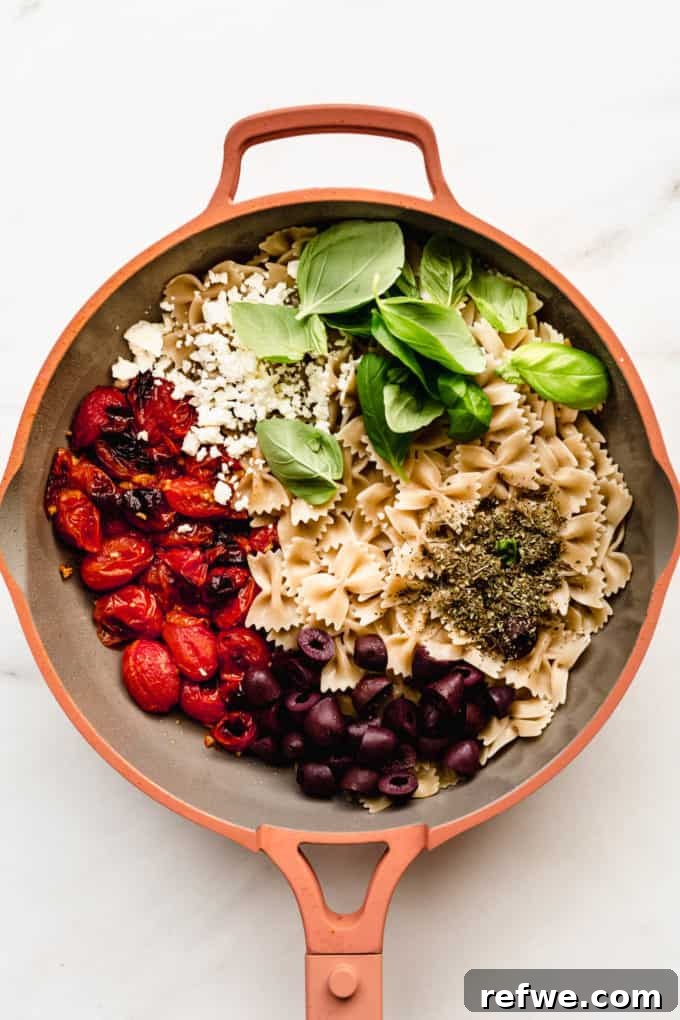 Sun-Drenched Mediterranean Pasta 4 Farfalle pasta, Kalamata olives, roasted cherry tomatoes, feta cheese and basil being mixed in a pan