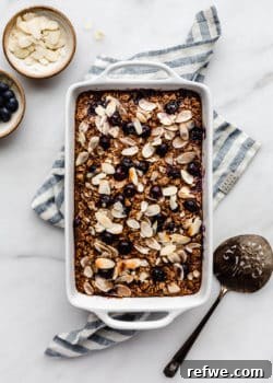 A baking dish with blueberry baked oatmeal in it on a blue napkin, ready to be served.