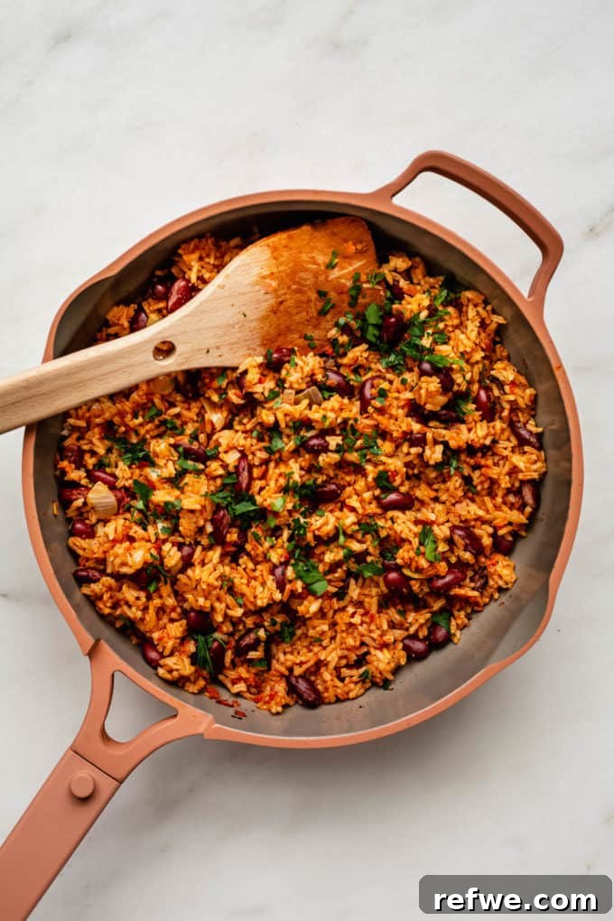 Classic Spanish Red Beans and Rice 7 A pan of Spanish rice and beans topped with fresh parsley