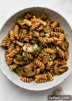vegan mushroom stroganoff in a white speckled ceramic bowl