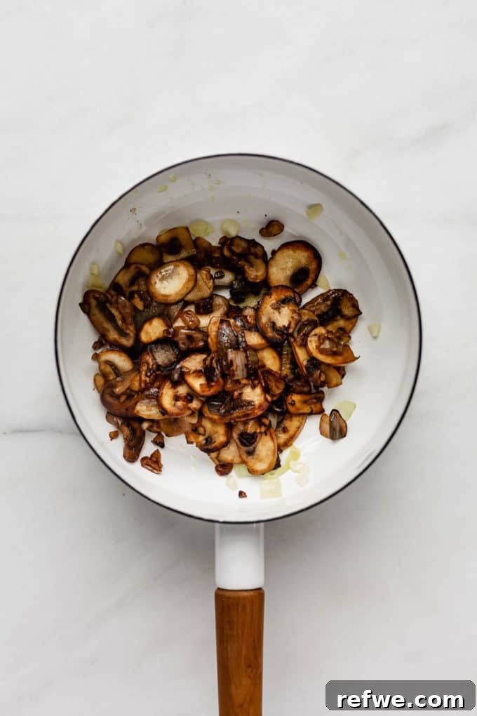 Plant-Powered Mushroom Stroganoff 5 A white pot containing perfectly sautéed, golden-brown mushrooms, ready for the sauce.