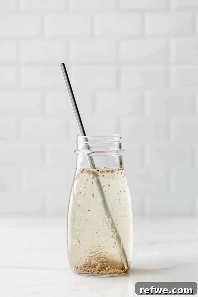 Cool Chia Quench 4 A refreshing chia seed drink served in a clear glass jar with a metallic straw, highlighting its delightful texture and inviting appearance, ready to be enjoyed.