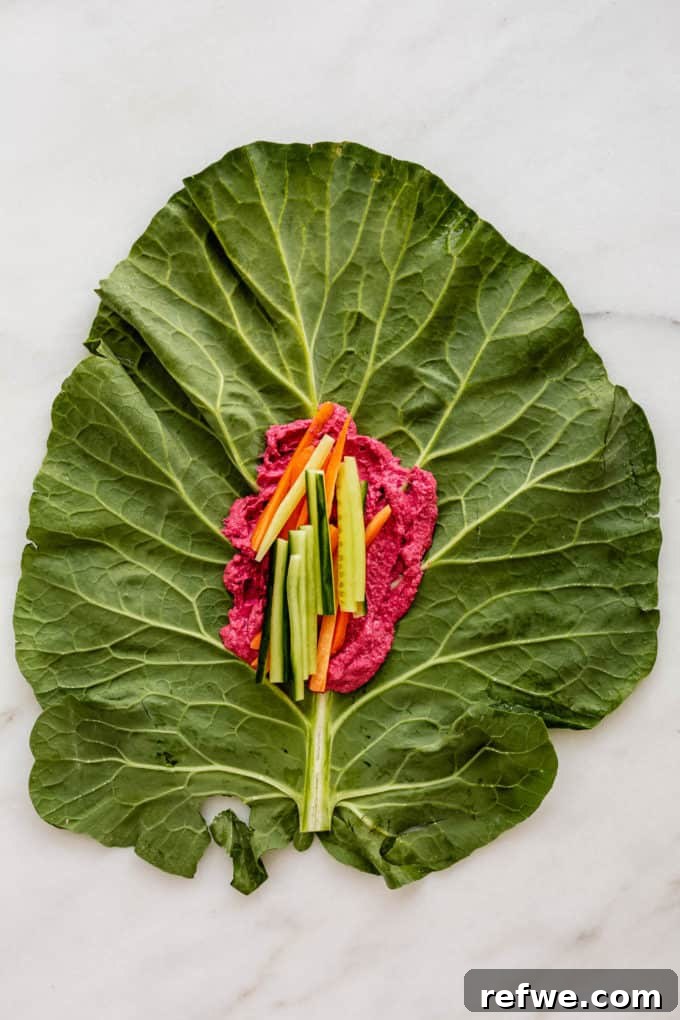 Vibrant Garden Collard Wraps 4 A collard green leaf with beet hummus spread along the center, topped with crisp cucumber slices.
