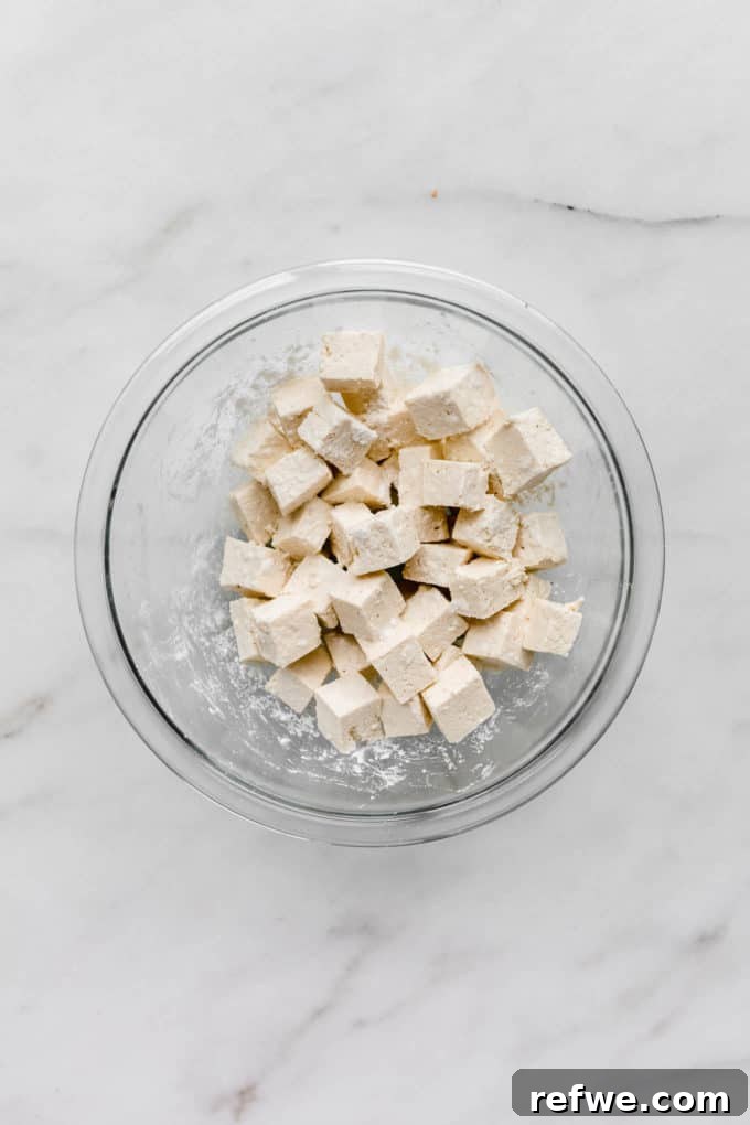 Sticky Teriyaki Glazed Crispy Tofu 3 cubed tofu in a clear mixing bowl