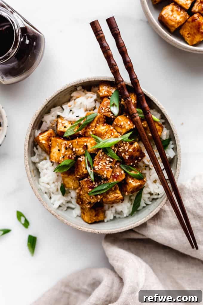 Sticky Teriyaki Glazed Crispy Tofu 7 A bowl of teriyaki tofu with a napkin on the side
