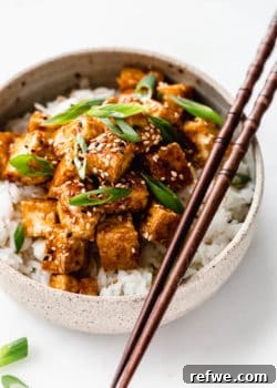 teriyaki tofu in a ceramic bowl with wooden chopsticks