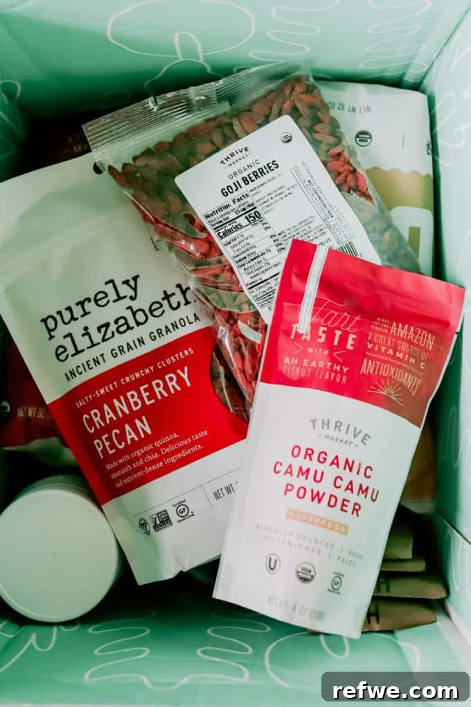 Thrive Market 2021 Is It Worth Your Money 2 A box filled with Thrive Market products including camu camu powder, granola, and goji berries, signifying healthy and organic choices.
