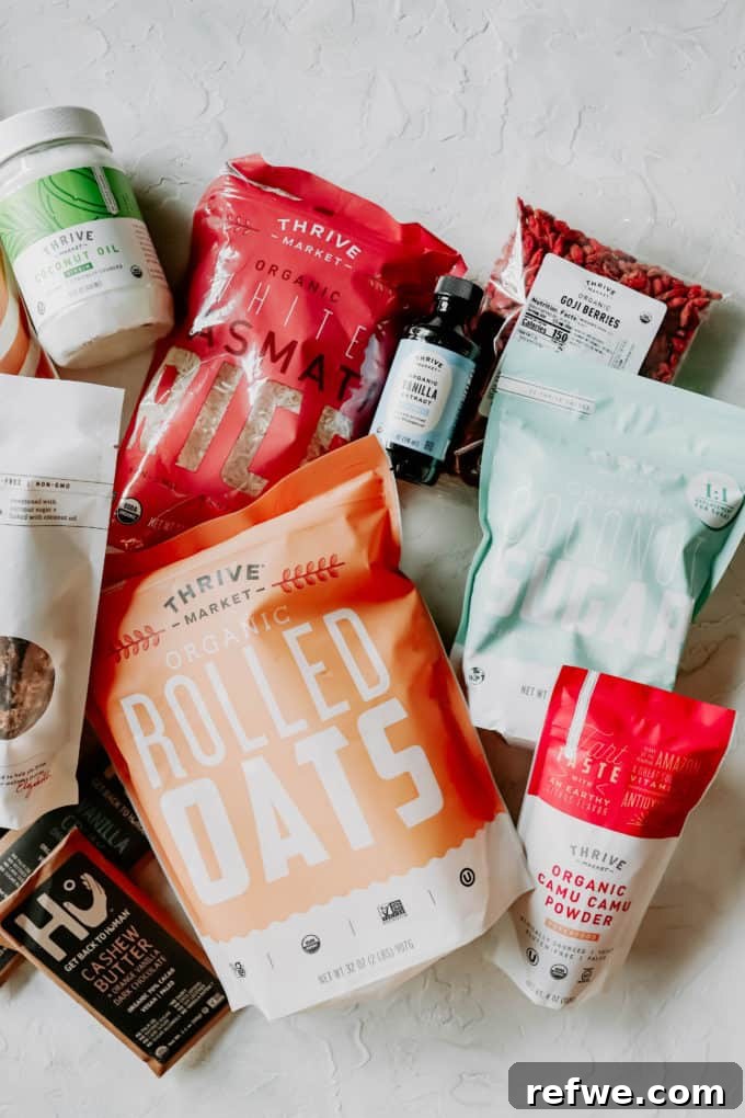 Thrive Market 2021 Is It Worth Your Money 7 A flat lay photograph of various healthy food products including rolled oats, organic chocolate, coconut sugar, and rice, all typical Thrive Market offerings.