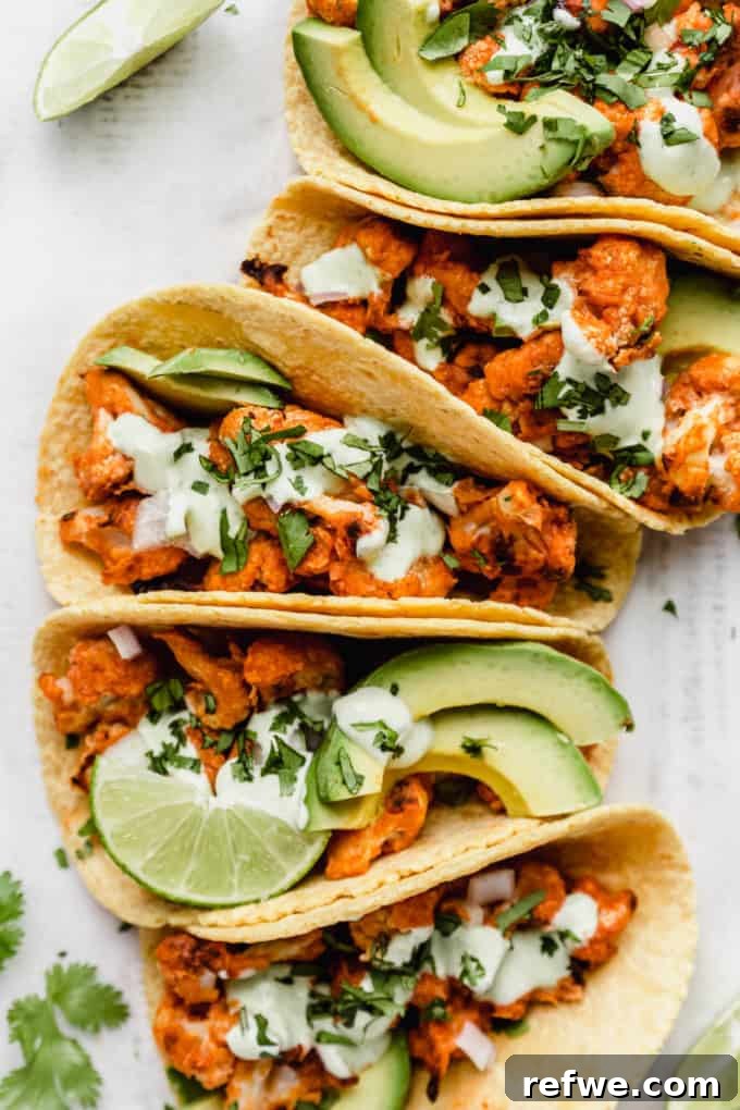 Tacos generously filled with buffalo cauliflower and creamy avocado slices