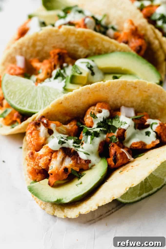 A close-up of a single taco stuffed generously with buffalo cauliflower