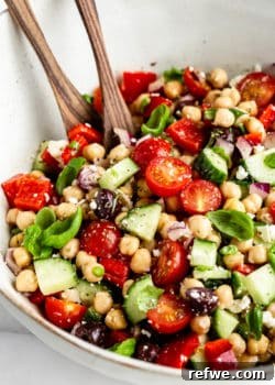 Mediterranean Chickpea Salad ingredients mixed in a bowl, showing fresh vegetables and chickpeas.